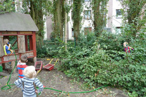 Kinder im Garten telefonieren mit einem Schlauchtelefon